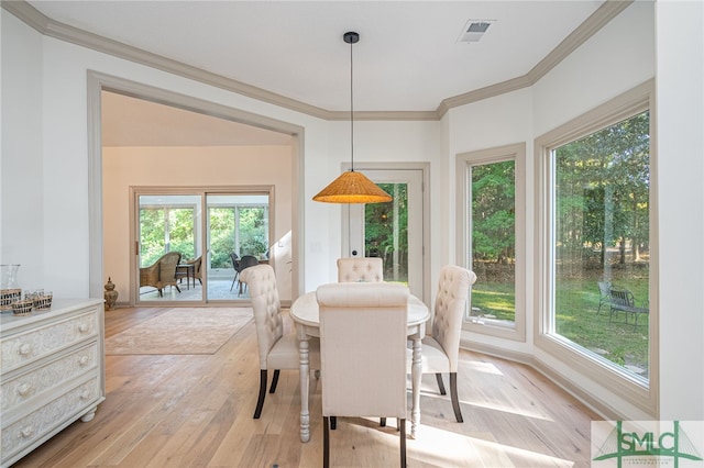 dining space with light wood-type flooring and crown molding