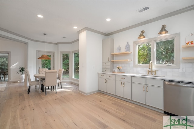 kitchen featuring backsplash, stainless steel dishwasher, sink, light hardwood / wood-style floors, and hanging light fixtures