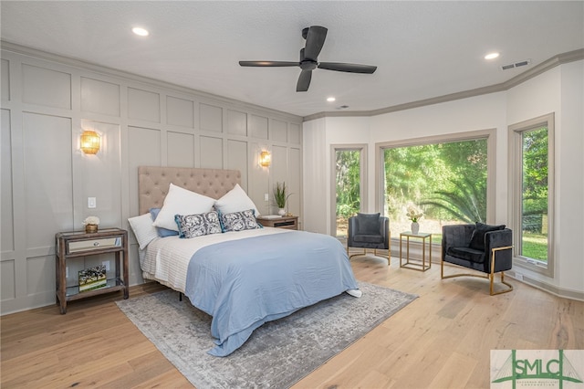 bedroom featuring ceiling fan, crown molding, light hardwood / wood-style floors, and a textured ceiling