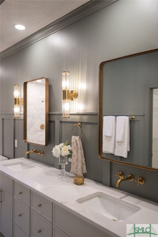 bathroom with a textured ceiling, vanity, and crown molding