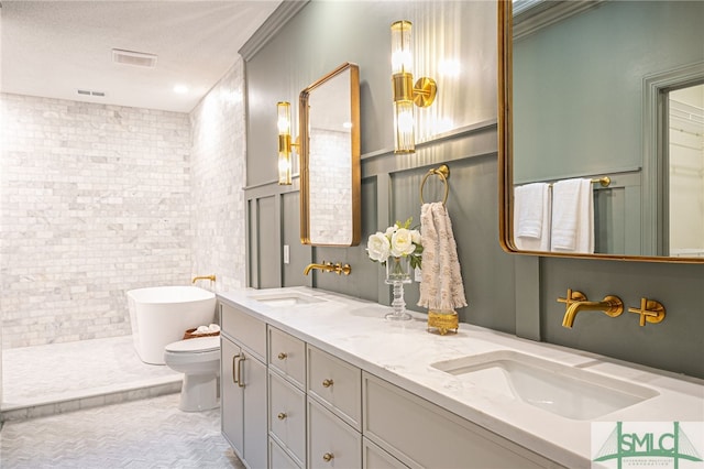 bathroom featuring a textured ceiling, toilet, a bathtub, vanity, and tile walls