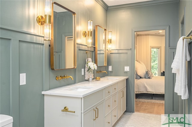 bathroom with wood-type flooring, vanity, toilet, and crown molding