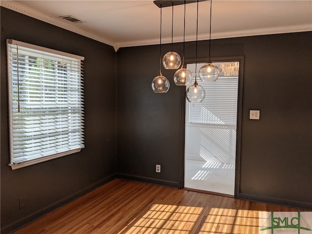 unfurnished dining area with crown molding and hardwood / wood-style floors