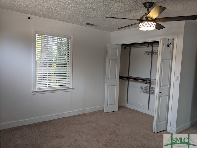 unfurnished bedroom featuring light carpet, a textured ceiling, a closet, and ceiling fan