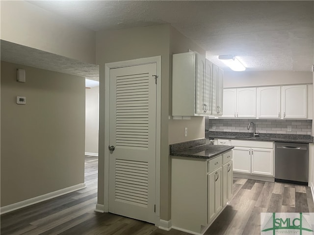 kitchen with decorative backsplash, dark wood-type flooring, stainless steel dishwasher, white cabinets, and a textured ceiling