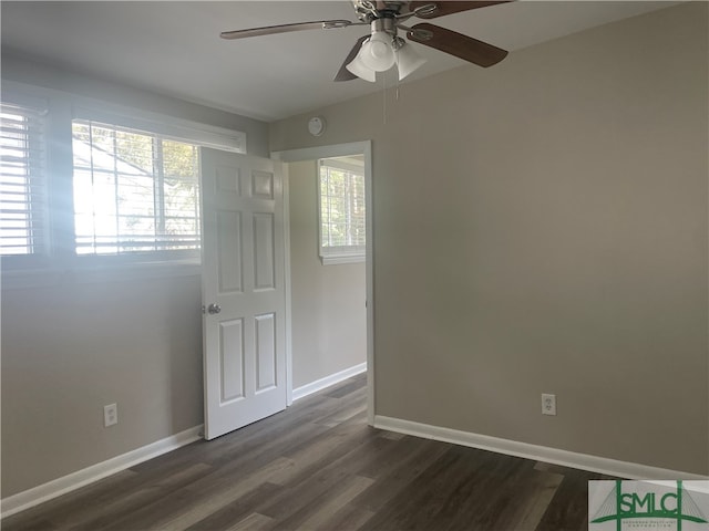 empty room featuring dark hardwood / wood-style flooring, ceiling fan, and plenty of natural light