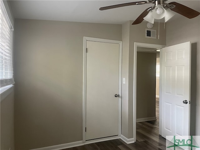 unfurnished bedroom with a closet, dark hardwood / wood-style floors, lofted ceiling, and ceiling fan