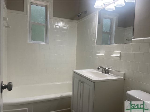 full bathroom with vanity, toilet, and tiled shower / bath combo