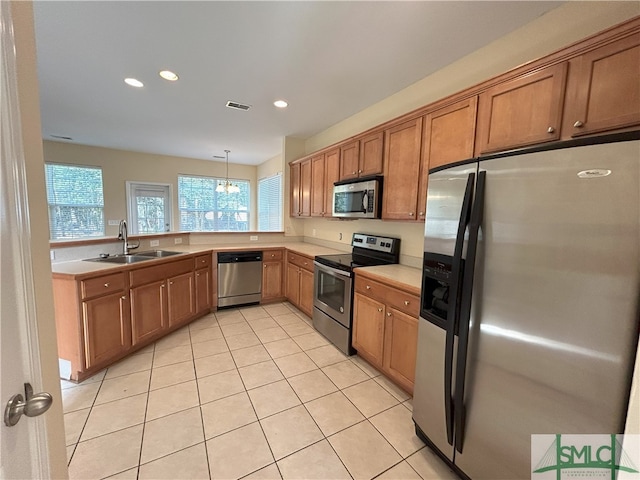 kitchen with sink, pendant lighting, stainless steel appliances, and light tile patterned floors