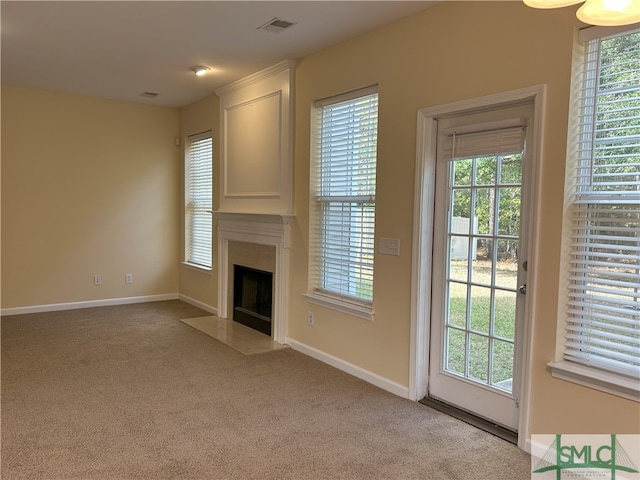 unfurnished living room with light carpet and a wealth of natural light