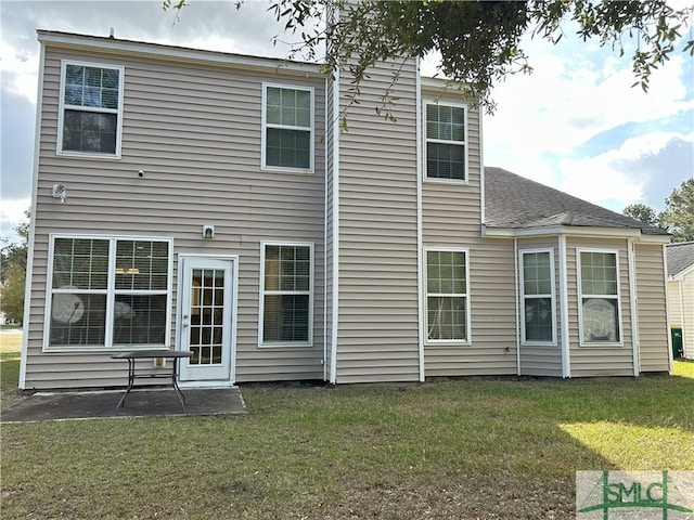 rear view of house with a patio area and a lawn