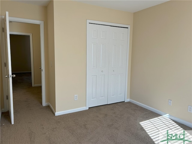 unfurnished bedroom with light carpet and a closet