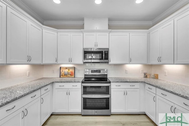 kitchen featuring crown molding, white cabinets, and stainless steel appliances