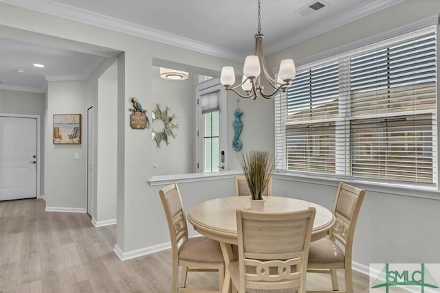 dining space with crown molding, a chandelier, and light wood-type flooring