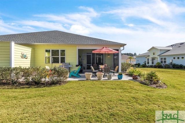 rear view of house with a patio area and a lawn