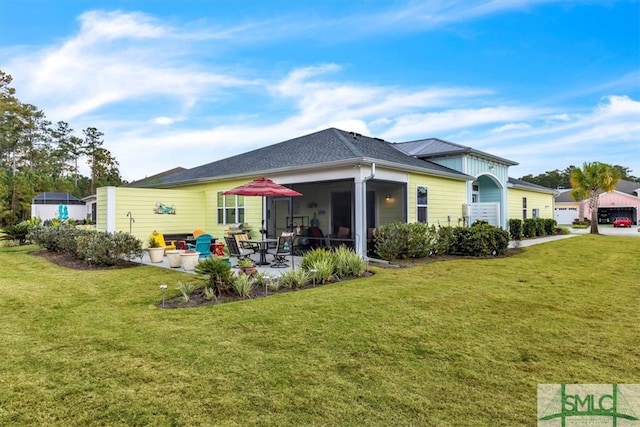 rear view of property featuring a yard and a sunroom