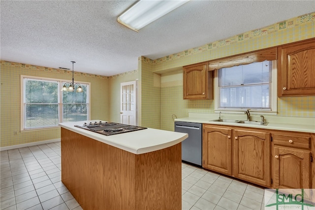 kitchen with stainless steel appliances, sink, pendant lighting, an inviting chandelier, and a textured ceiling