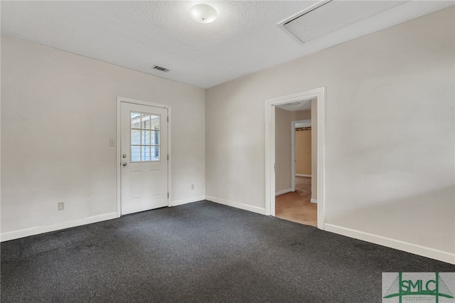 carpeted empty room featuring a textured ceiling