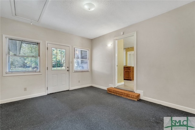 carpeted empty room featuring a textured ceiling