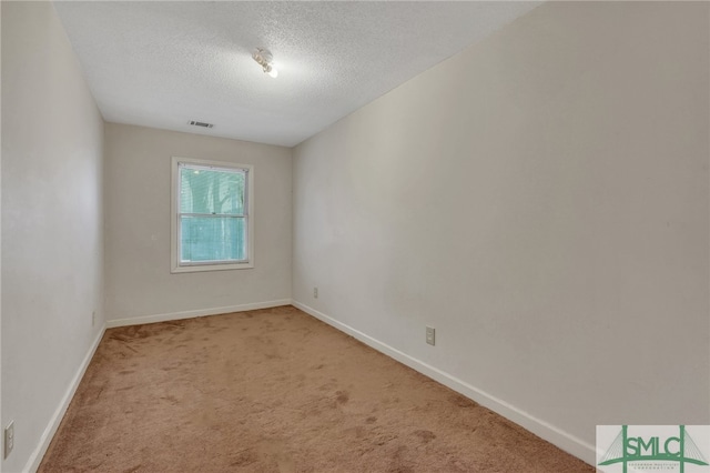 carpeted empty room with a textured ceiling