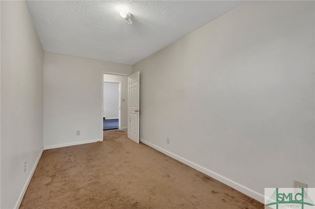 carpeted empty room featuring a textured ceiling