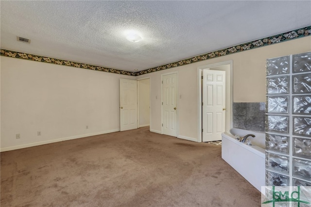 unfurnished room featuring a textured ceiling and carpet floors