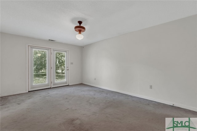 carpeted spare room featuring a textured ceiling