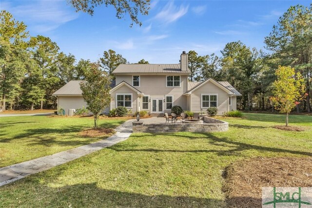 5261 Mill Branch Club Rd, Pembroke, GA 31321 - rear view of property featuring an outdoor fire pit, a chimney, a yard, a patio area, and metal roof