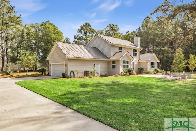 view of front facade featuring central AC, a front lawn, and a garage