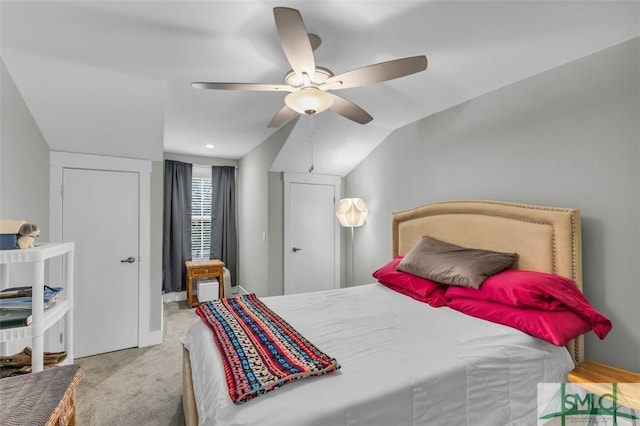 bedroom featuring vaulted ceiling, light colored carpet, and ceiling fan