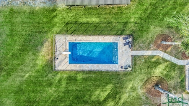 view of swimming pool featuring a yard