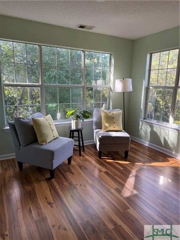 living area with wood-type flooring and a textured ceiling