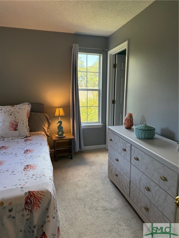 bedroom with a textured ceiling and light colored carpet