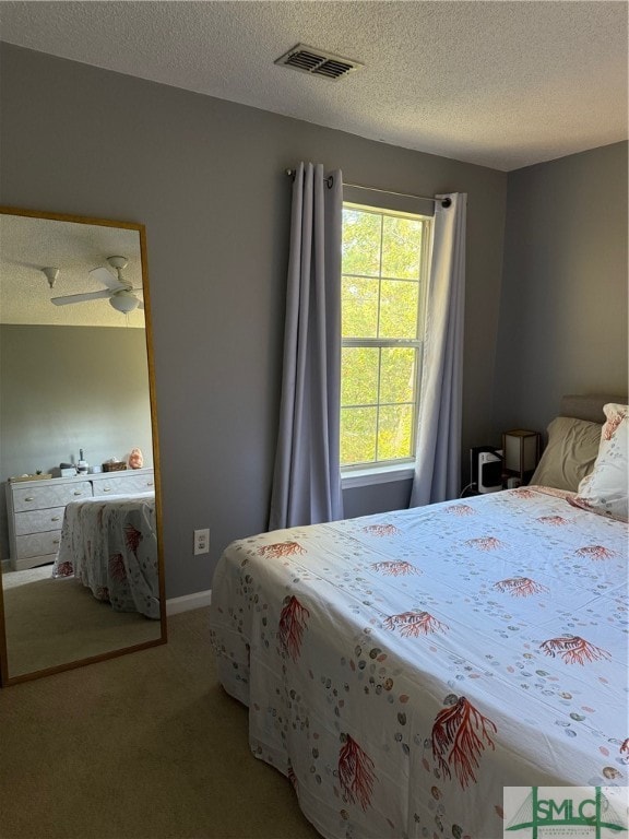 bedroom featuring ceiling fan, carpet flooring, and a textured ceiling