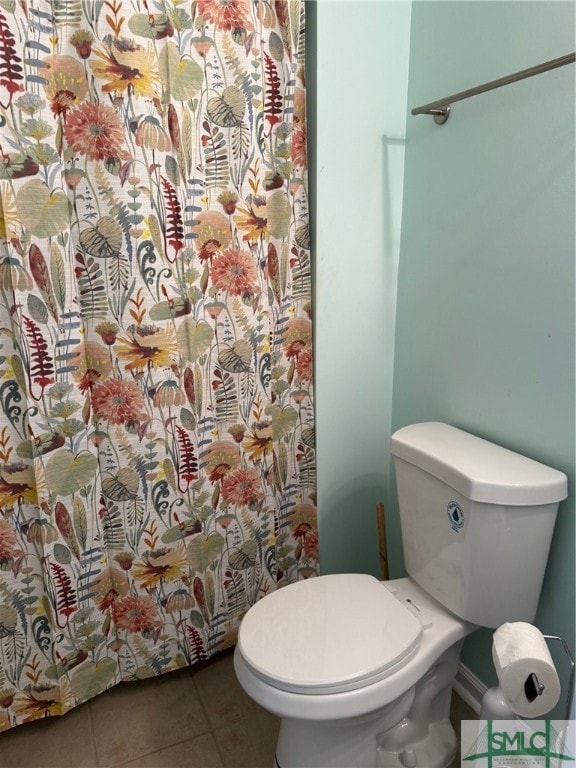 bathroom featuring toilet, tile patterned floors, and a shower with curtain