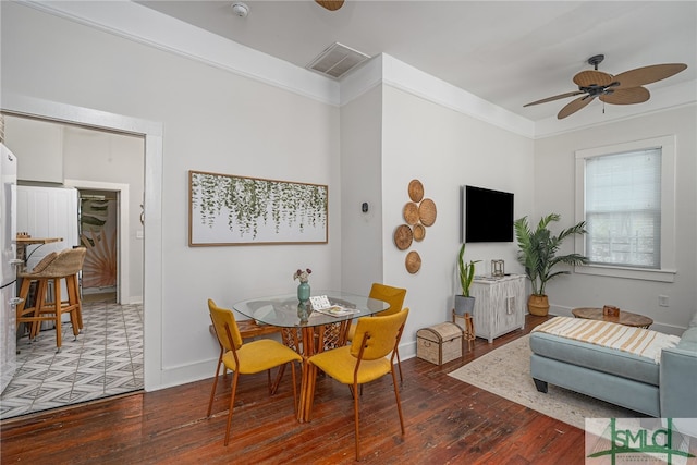 dining room with dark hardwood / wood-style flooring, ceiling fan, and ornamental molding