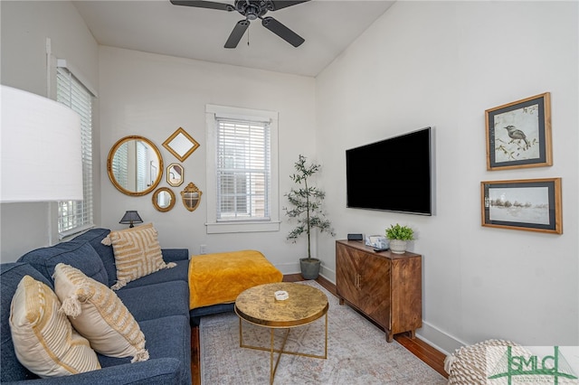 living room featuring ceiling fan, light hardwood / wood-style flooring, and vaulted ceiling