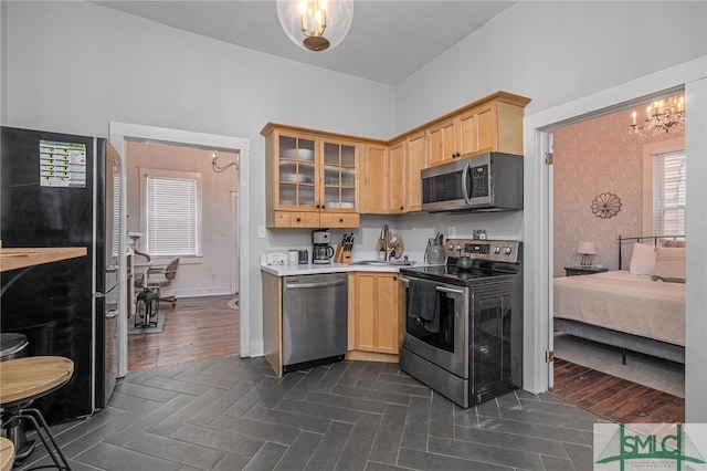 kitchen with sink, light brown cabinetry, dark hardwood / wood-style flooring, stainless steel appliances, and a chandelier