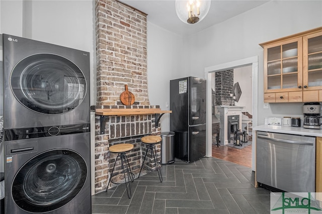 clothes washing area with dark wood-type flooring and stacked washer and clothes dryer