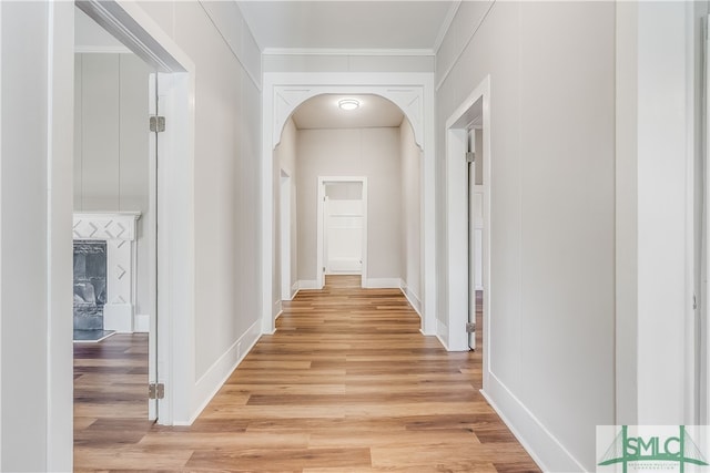 hall with crown molding and light hardwood / wood-style flooring