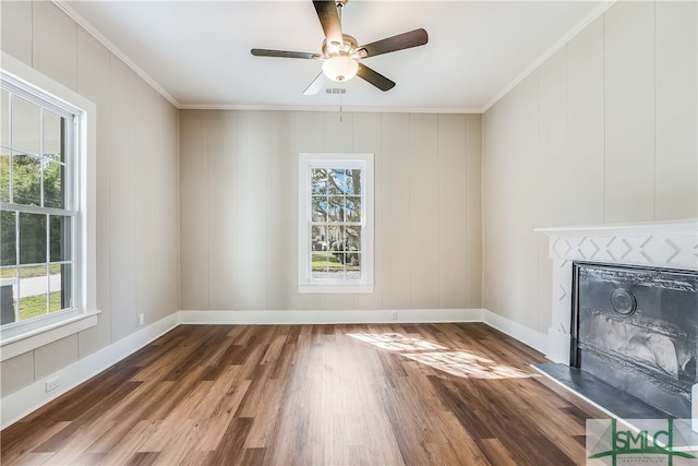 unfurnished living room featuring crown molding, dark wood-type flooring, and ceiling fan