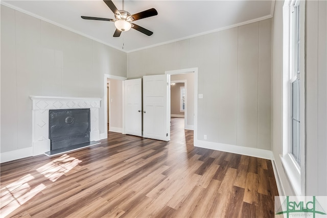 unfurnished living room with hardwood / wood-style floors, crown molding, and ceiling fan