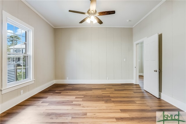 empty room featuring crown molding, ceiling fan, and light wood-type flooring