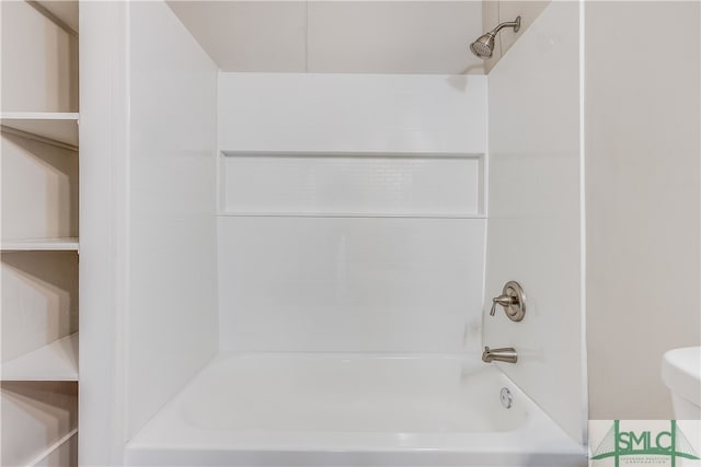 bathroom with tiled shower / bath combo and toilet