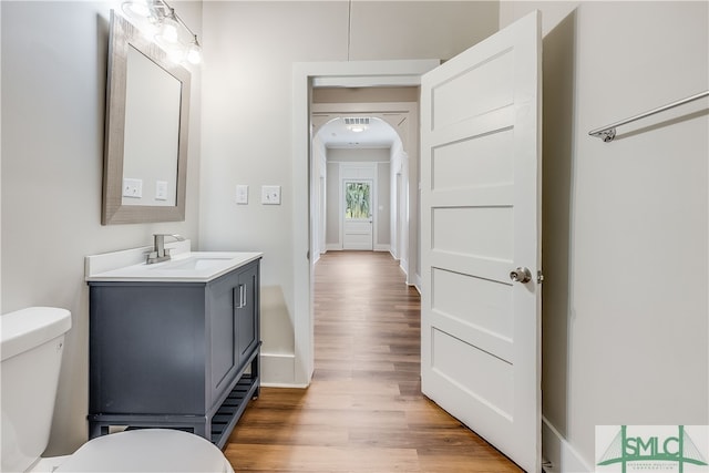 bathroom with vanity, wood-type flooring, and toilet