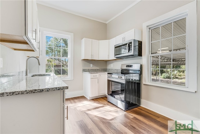 kitchen featuring sink, light stone counters, ornamental molding, stainless steel appliances, and white cabinets