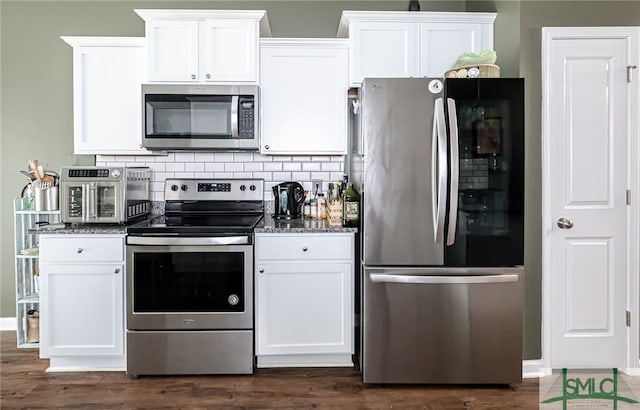 kitchen with white cabinets, stainless steel appliances, and backsplash