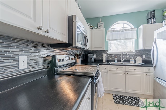 kitchen featuring dark countertops, white cabinetry, appliances with stainless steel finishes, and a sink