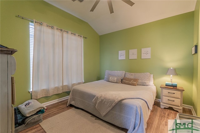 bedroom featuring a ceiling fan, vaulted ceiling, baseboards, and wood finished floors