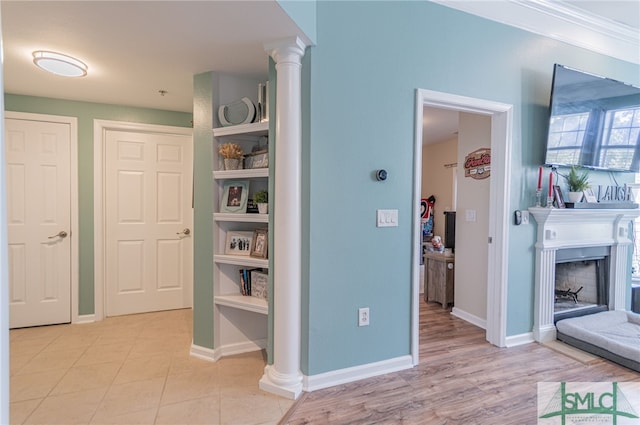 corridor featuring ornate columns, ornamental molding, and baseboards